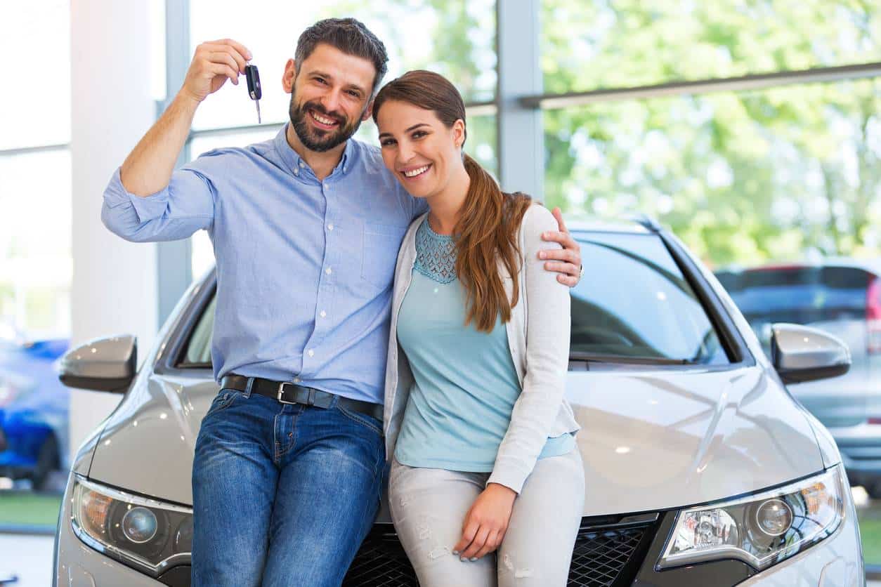 Un couple qui vient d'acheter une voiture neuve chez un concessionnaire