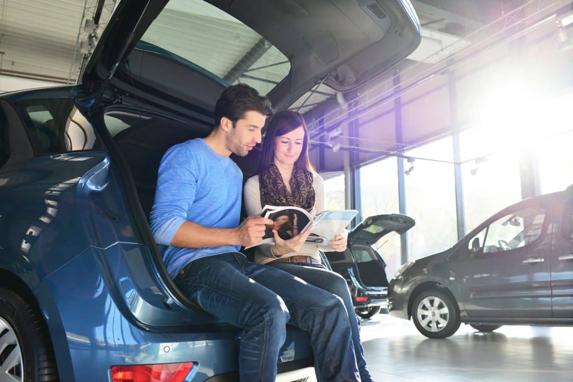 Un couple en train de choisir une voiture bénéficiant d'un prêt à taux zéro