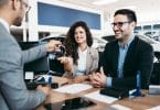 Une couple en train de contracter un financement pour acheter leur voiture
